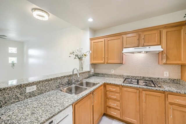 kitchen with sink, tasteful backsplash, stainless steel gas stovetop, and light stone countertops