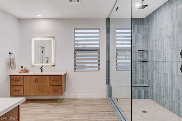 bathroom featuring tile patterned floors, vanity, and a tile shower