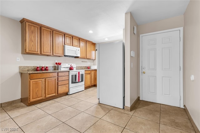 kitchen featuring white appliances and light tile patterned floors