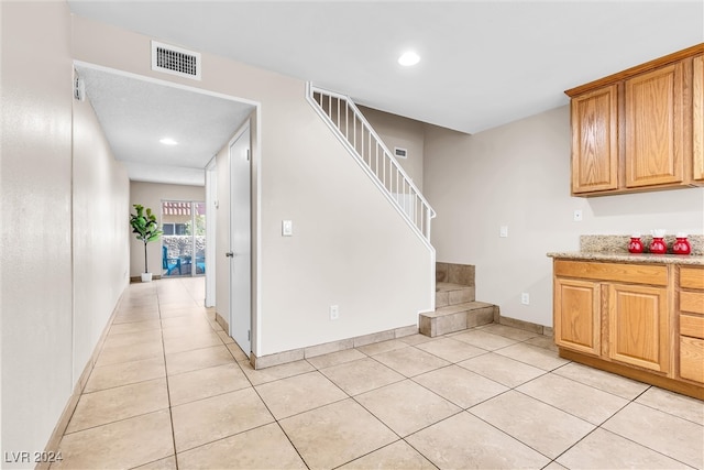 interior space with light tile patterned flooring and light stone countertops