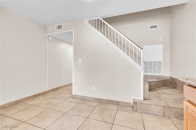 stairs featuring light tile patterned flooring