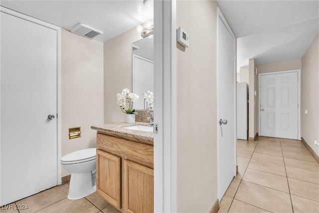 bathroom featuring vanity, tile patterned flooring, and toilet