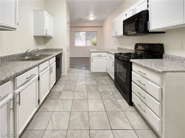 kitchen featuring black appliances, kitchen peninsula, white cabinetry, and sink