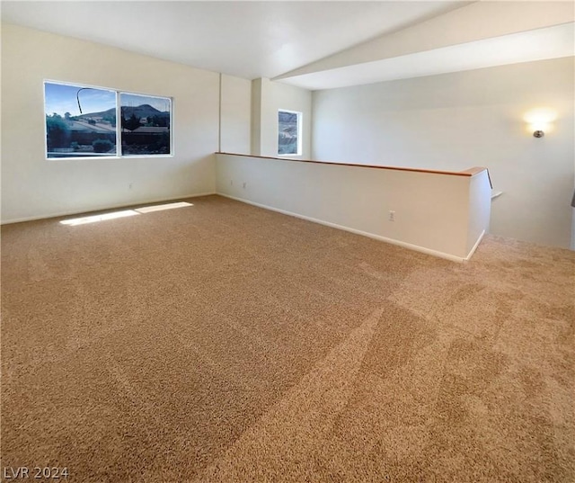 unfurnished room featuring carpet flooring and lofted ceiling