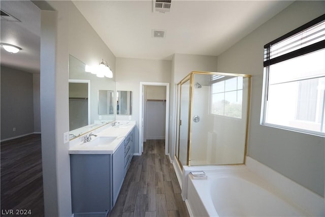 bathroom featuring independent shower and bath, vanity, a healthy amount of sunlight, and wood-type flooring