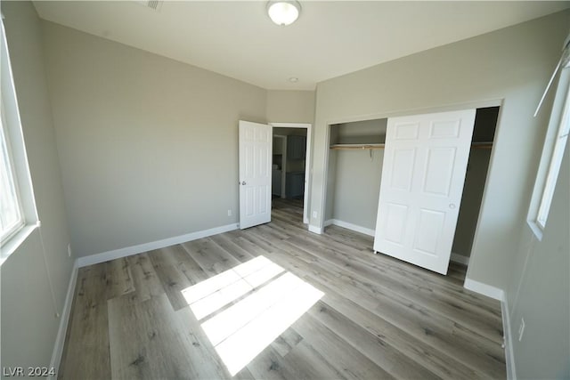 unfurnished bedroom featuring light hardwood / wood-style flooring and a closet