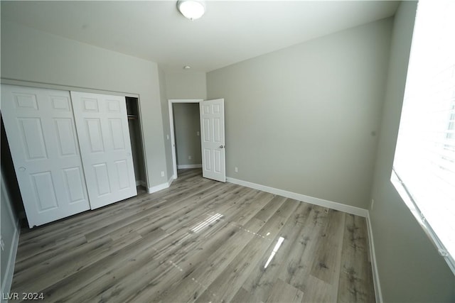 unfurnished bedroom with light hardwood / wood-style floors and a closet