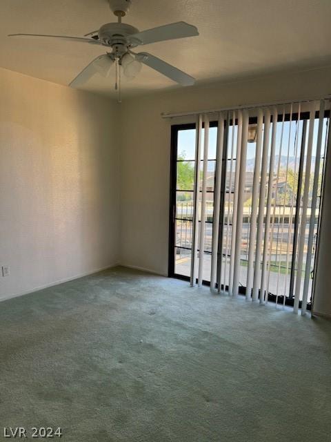 carpeted empty room featuring ceiling fan