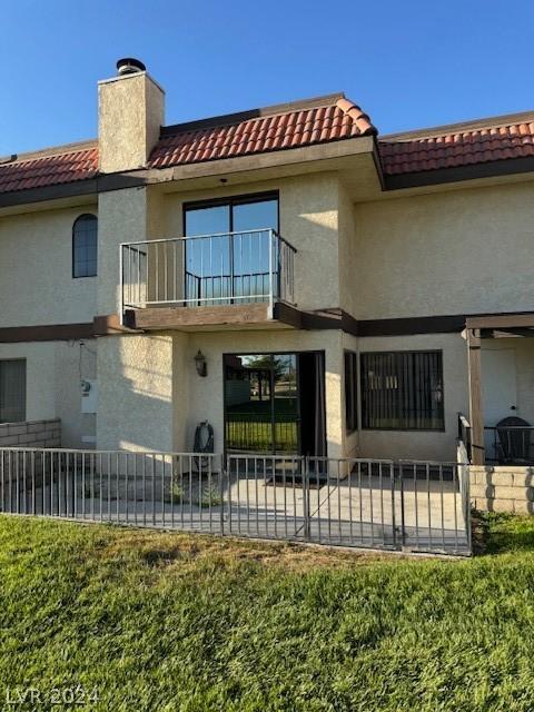 rear view of house featuring a patio area and a balcony