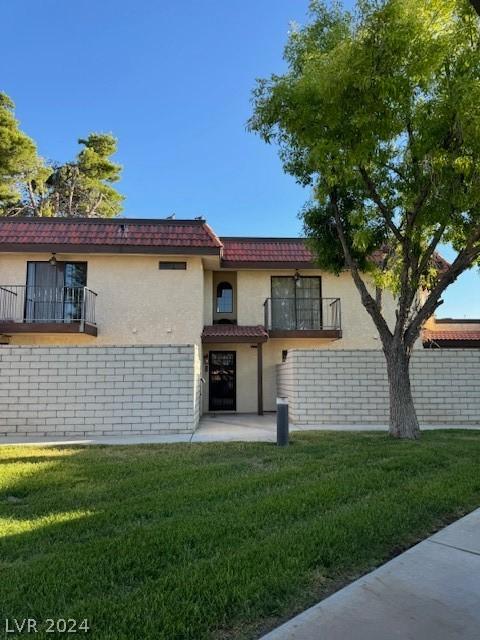 view of front of property with a balcony and a front yard