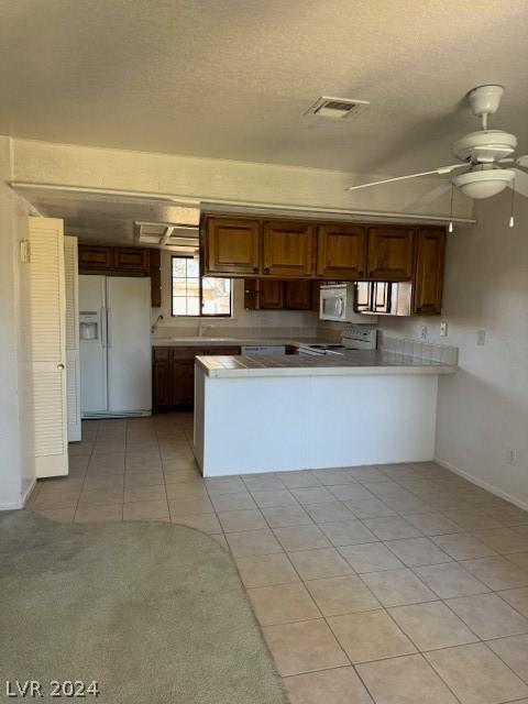 kitchen featuring ceiling fan, white appliances, a textured ceiling, light tile floors, and sink