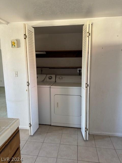 washroom featuring washer and clothes dryer and light tile patterned floors