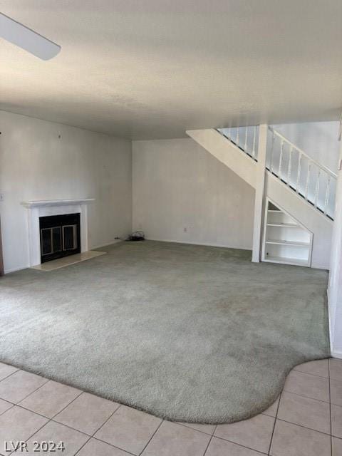 unfurnished living room with light colored carpet and built in features