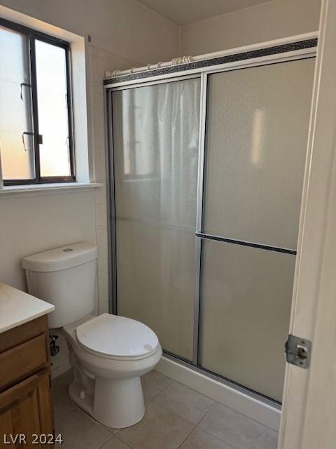 bathroom featuring an enclosed shower, vanity, toilet, and tile floors