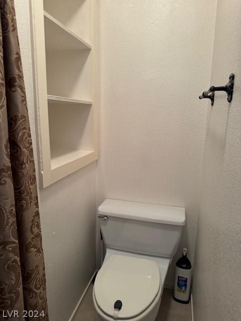 bathroom featuring tile floors and toilet