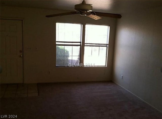 carpeted spare room with ceiling fan