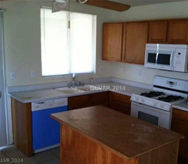 kitchen with ceiling fan, sink, a kitchen island, and white appliances