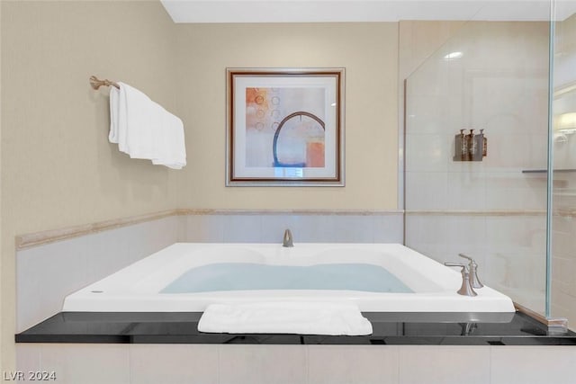 bathroom featuring a relaxing tiled tub