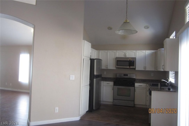 kitchen featuring stainless steel appliances, dark wood-type flooring, sink, decorative light fixtures, and white cabinets