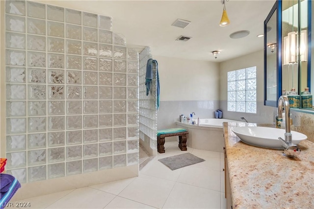 bathroom featuring tile patterned floors, vanity, and shower with separate bathtub