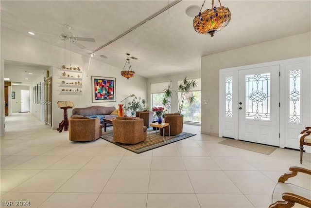 foyer entrance featuring light tile patterned floors, ceiling fan, and lofted ceiling