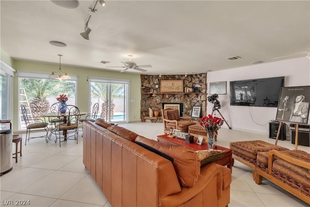 living room featuring ceiling fan, a fireplace, light tile patterned floors, and track lighting