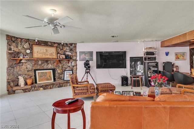 living room featuring ceiling fan, light tile patterned flooring, and a fireplace