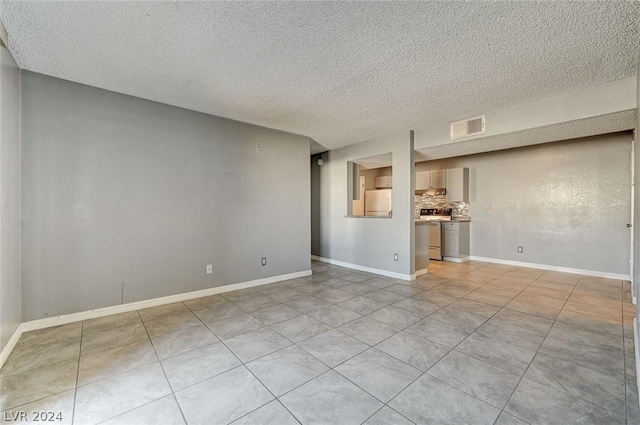 unfurnished living room featuring light tile patterned floors and a textured ceiling