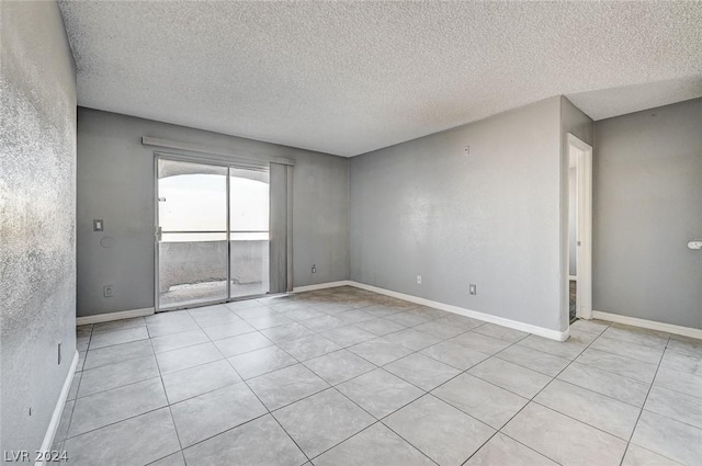 tiled empty room with a textured ceiling