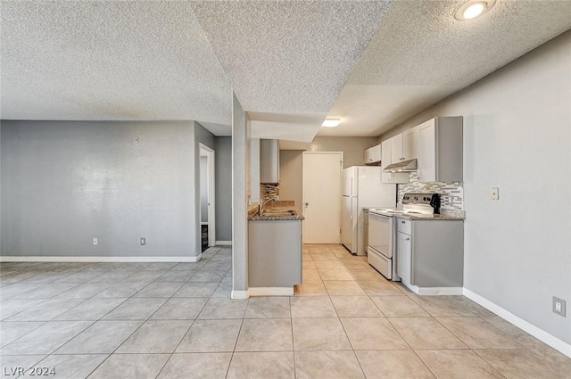 kitchen featuring tasteful backsplash, stone countertops, sink, and white appliances