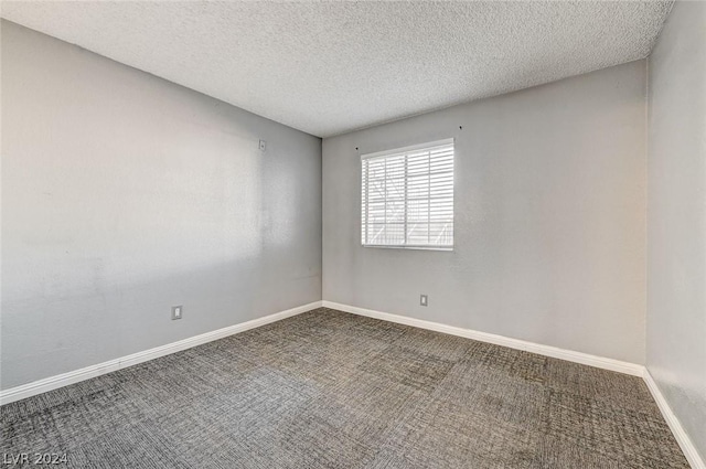 carpeted empty room with a textured ceiling