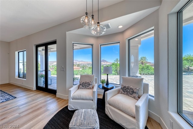 sitting room with a healthy amount of sunlight, a chandelier, and light hardwood / wood-style flooring