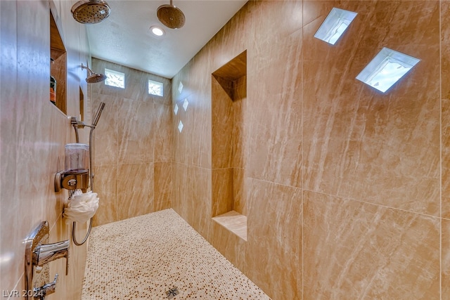 bathroom with tiled shower and tile walls