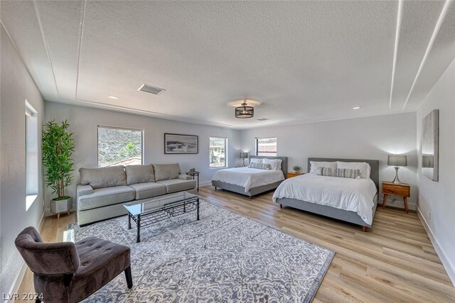 bedroom with a textured ceiling and light wood-type flooring