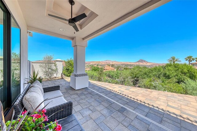 view of patio with ceiling fan and a mountain view