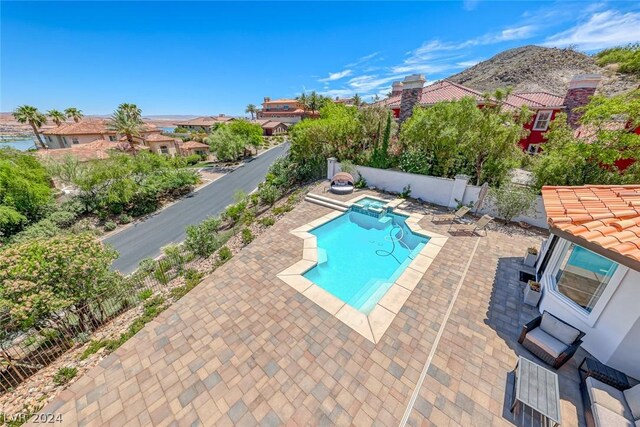 view of swimming pool with a patio area and a mountain view