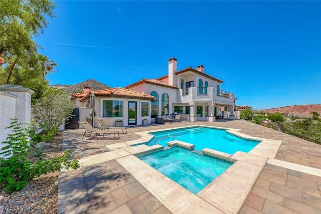 view of swimming pool with an in ground hot tub and a patio