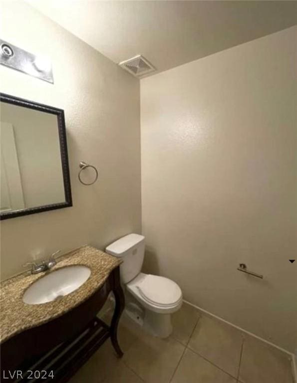 bathroom with toilet, tile patterned flooring, and sink