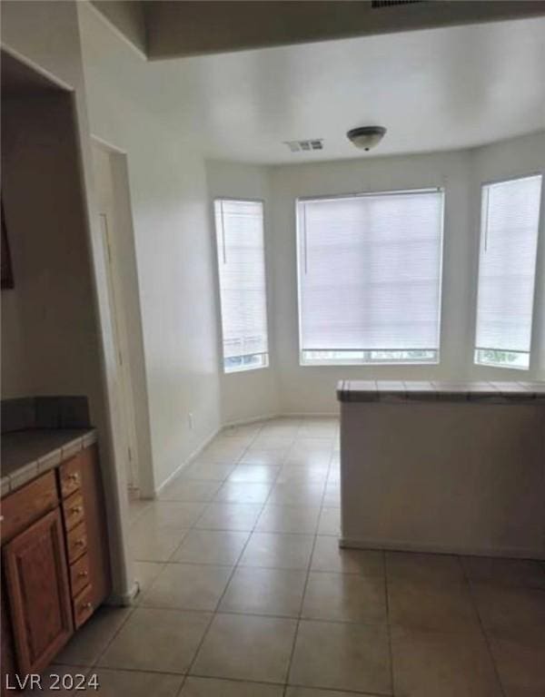 unfurnished dining area with a wealth of natural light and light tile patterned floors