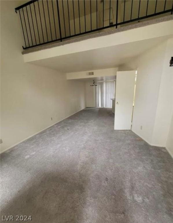 empty room with carpet and a high ceiling