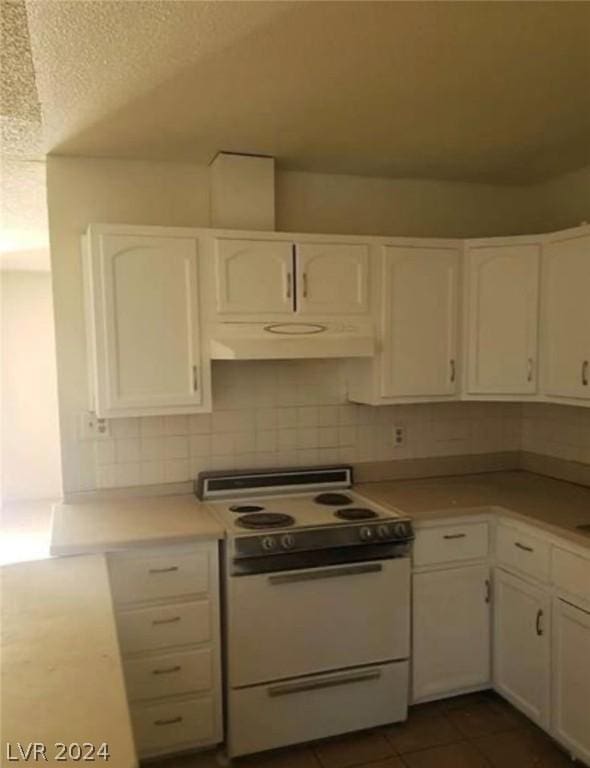 kitchen with decorative backsplash, white cabinetry, dark tile patterned floors, and white range with electric cooktop