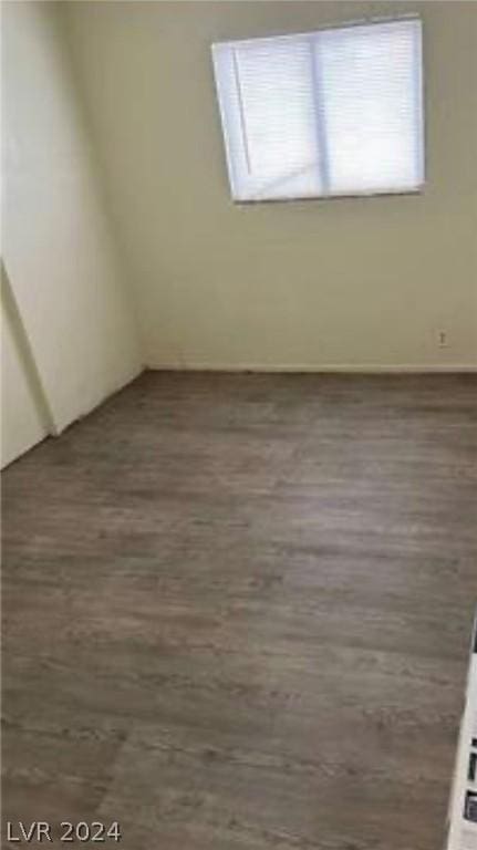 unfurnished room with dark wood-type flooring