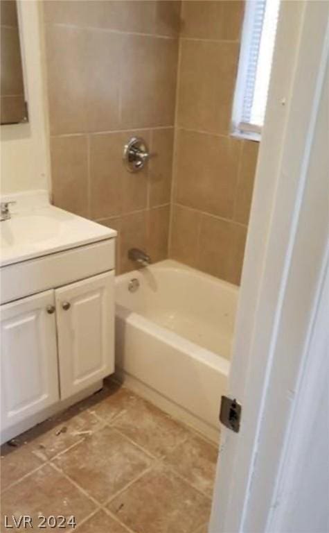 bathroom featuring tiled shower / bath combo and vanity