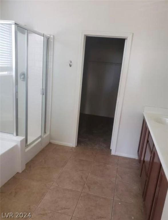 bathroom with tile patterned flooring, vanity, and plus walk in shower