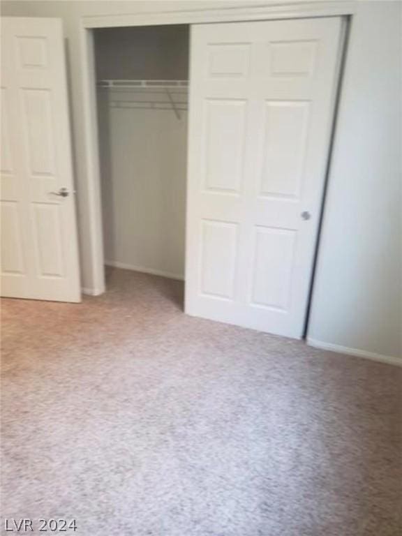 unfurnished bedroom with a closet and carpet flooring