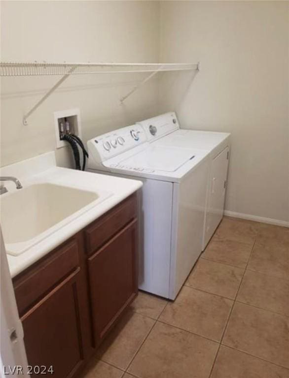 laundry room with light tile patterned flooring, cabinets, washer and clothes dryer, and sink