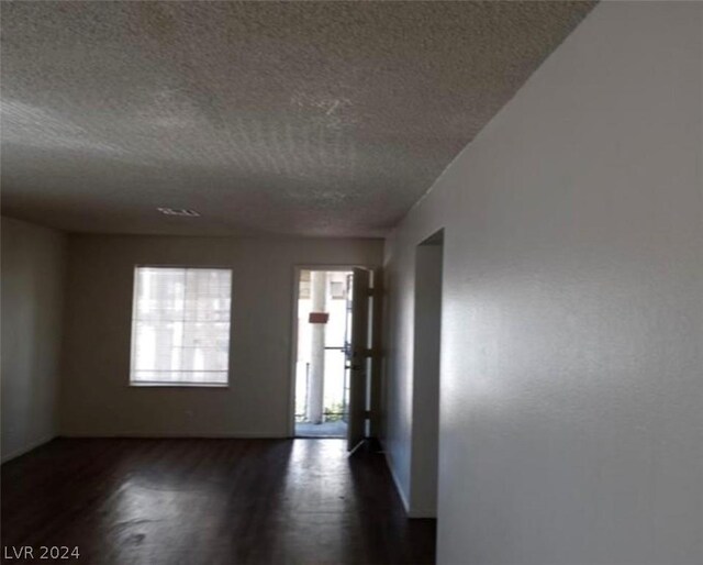 interior space featuring dark hardwood / wood-style flooring and a textured ceiling