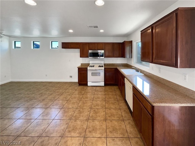 kitchen featuring sink, white appliances, and light tile patterned flooring