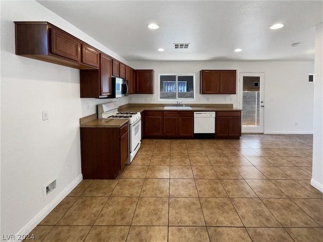 kitchen with sink, white appliances, and light tile patterned floors