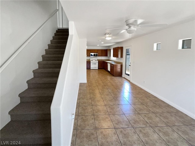 stairway with sink, tile patterned flooring, and ceiling fan